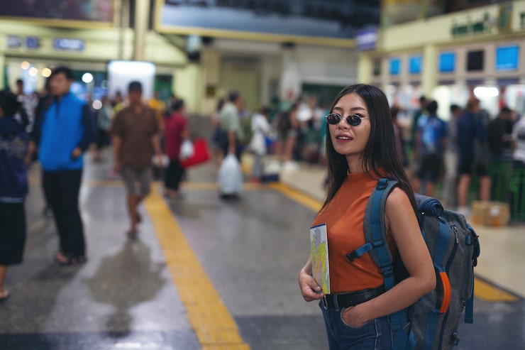 women enjoy traveling map train station